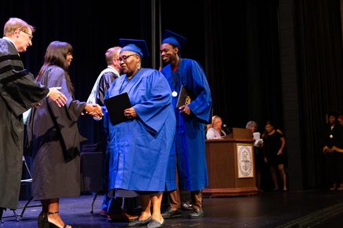 Portia and grandson Jaevon Ponds walk across the graduation stage
